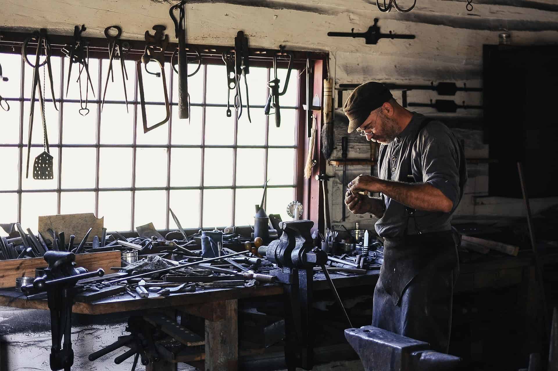 Handwerker arbeitet in der Werkstatt mit Werkzeugen und Maschinen.