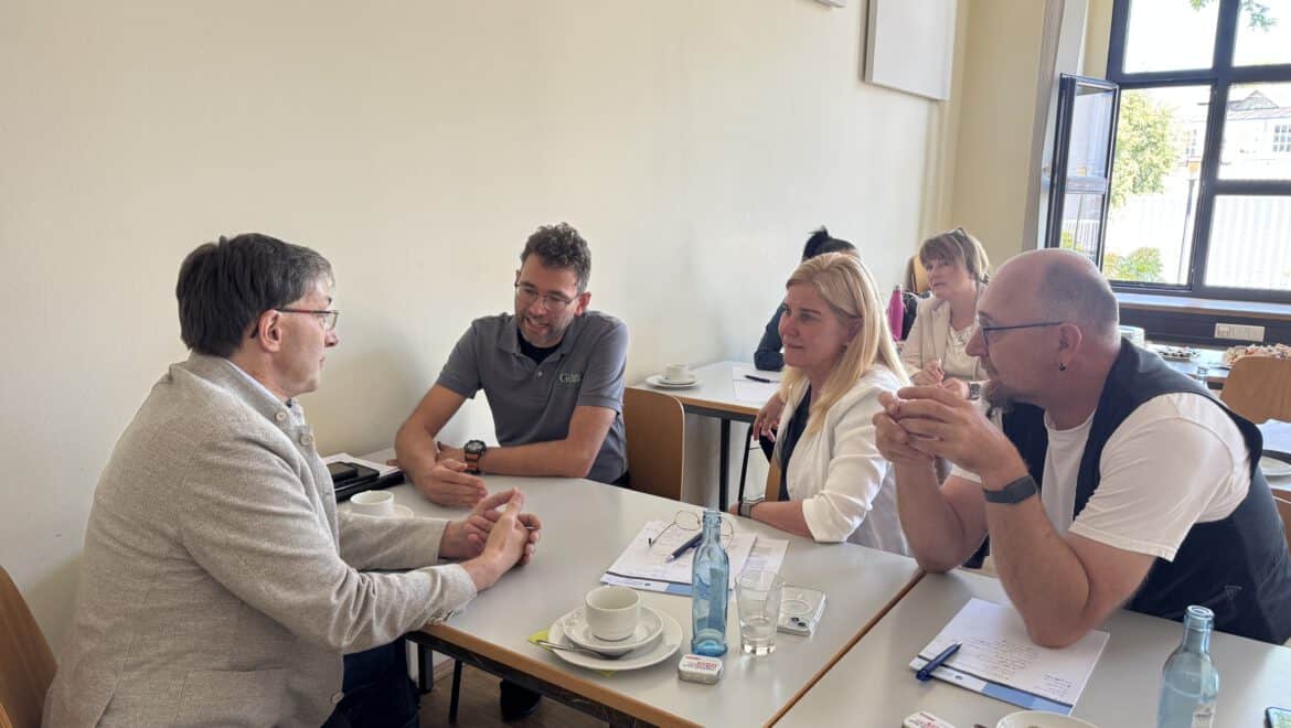Menschen im Gespräch bei einem Treffen in Karlsruhe, Fokus auf Ehrenamt.