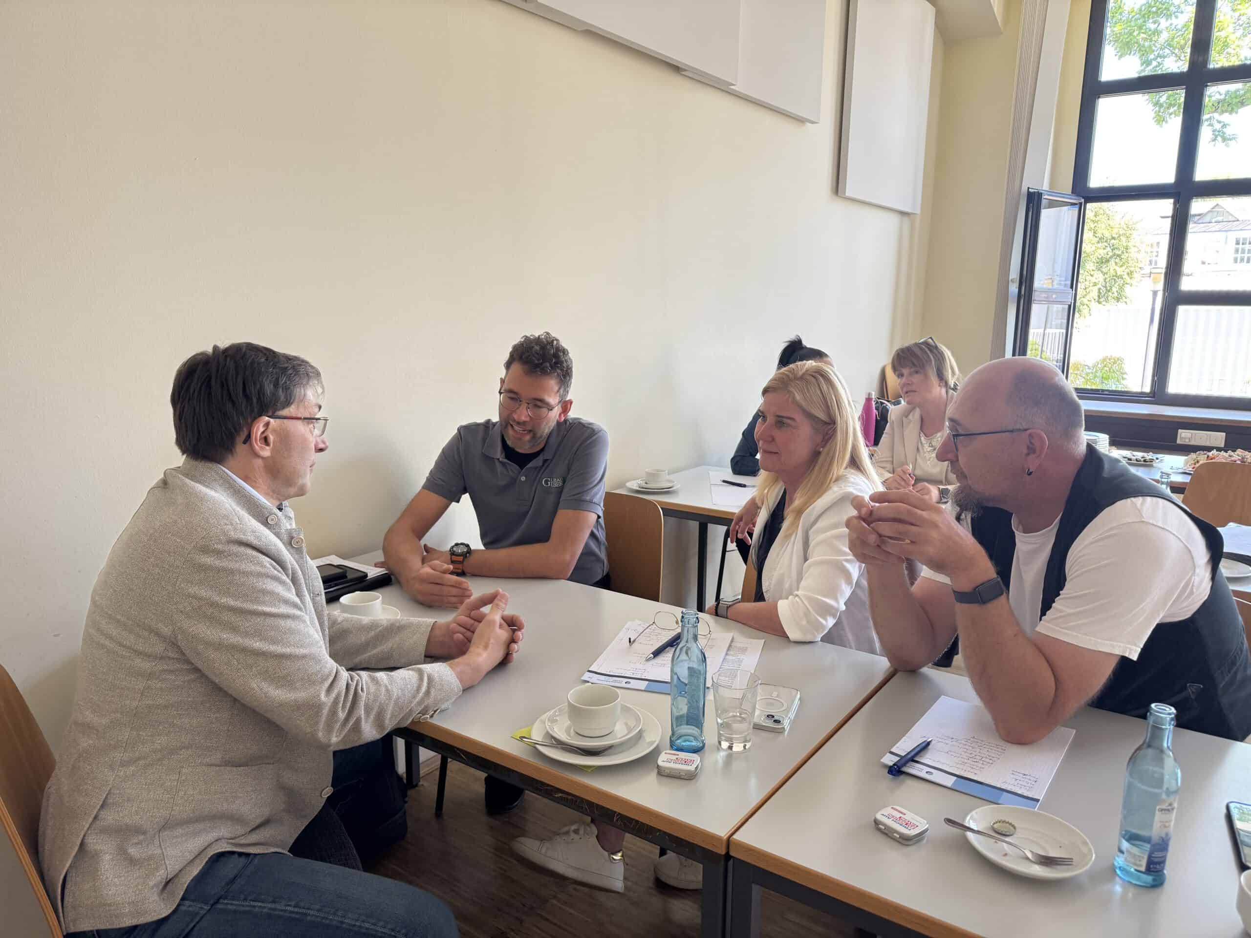 Menschen im Gespräch bei einem Treffen in Karlsruhe, Fokus auf Ehrenamt.